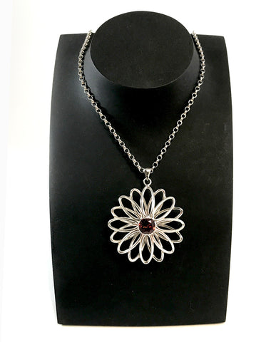 Silver daisy pendant with garnet by Selwyn Gale