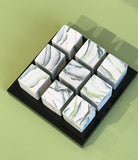 9 small cubes on black plinth by Kim Colebrook