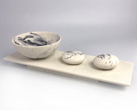 Rocking bowl and pebbles on plinth by Kim Colebrook
