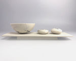 Rocking bowl and pebbles on plinth by Kim Colebrook