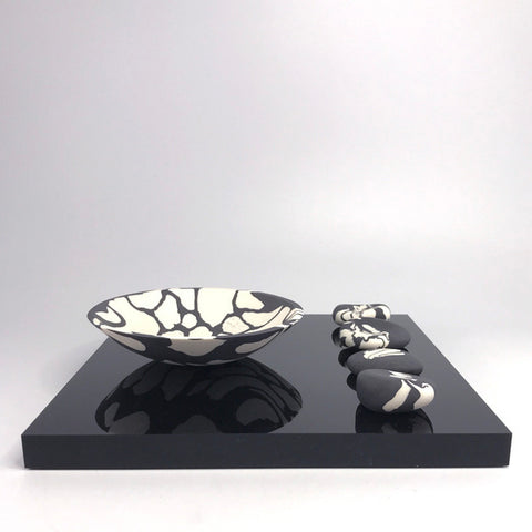 Wide rocking bowl and 4 pebbles on plinth by Kim Colebrook