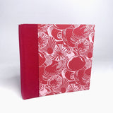 Shells on red sketchbook by Carole King